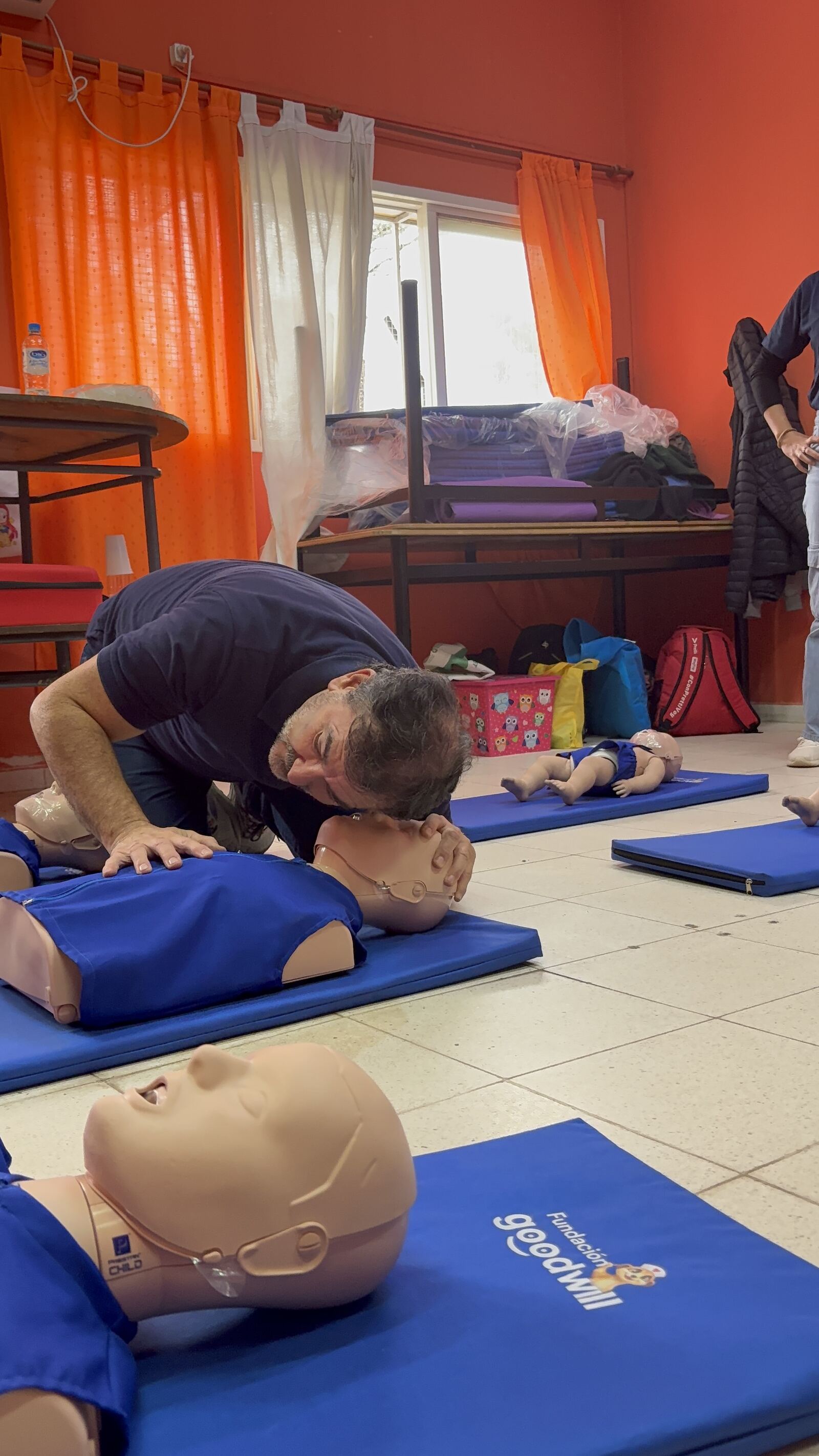 Taller de RCP: el instructor sobre el maniquí, con la fila de maniquíes detrás.
