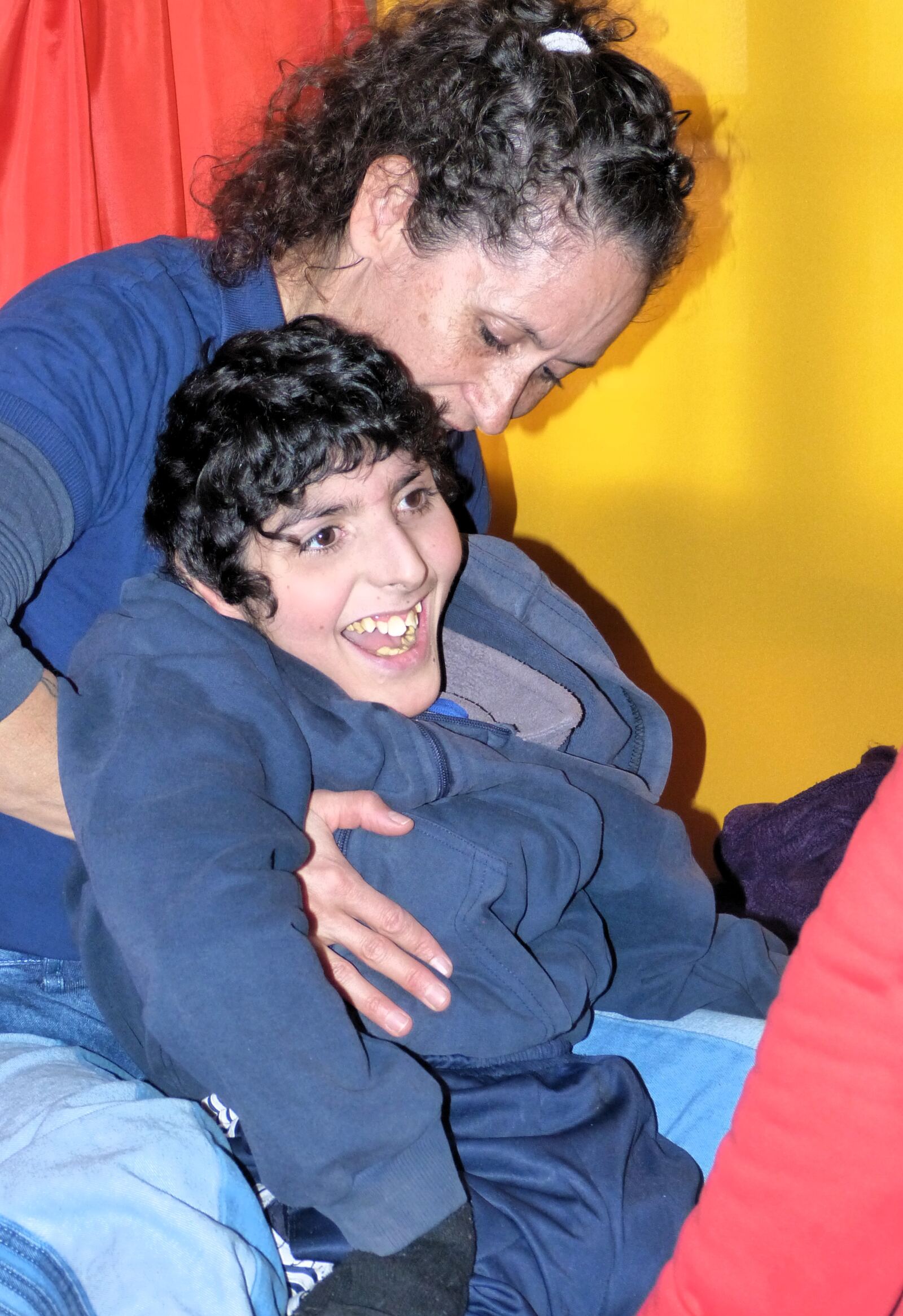 Una mamá abraza a su hijo, que se ríe, durante un operativo de la fundación