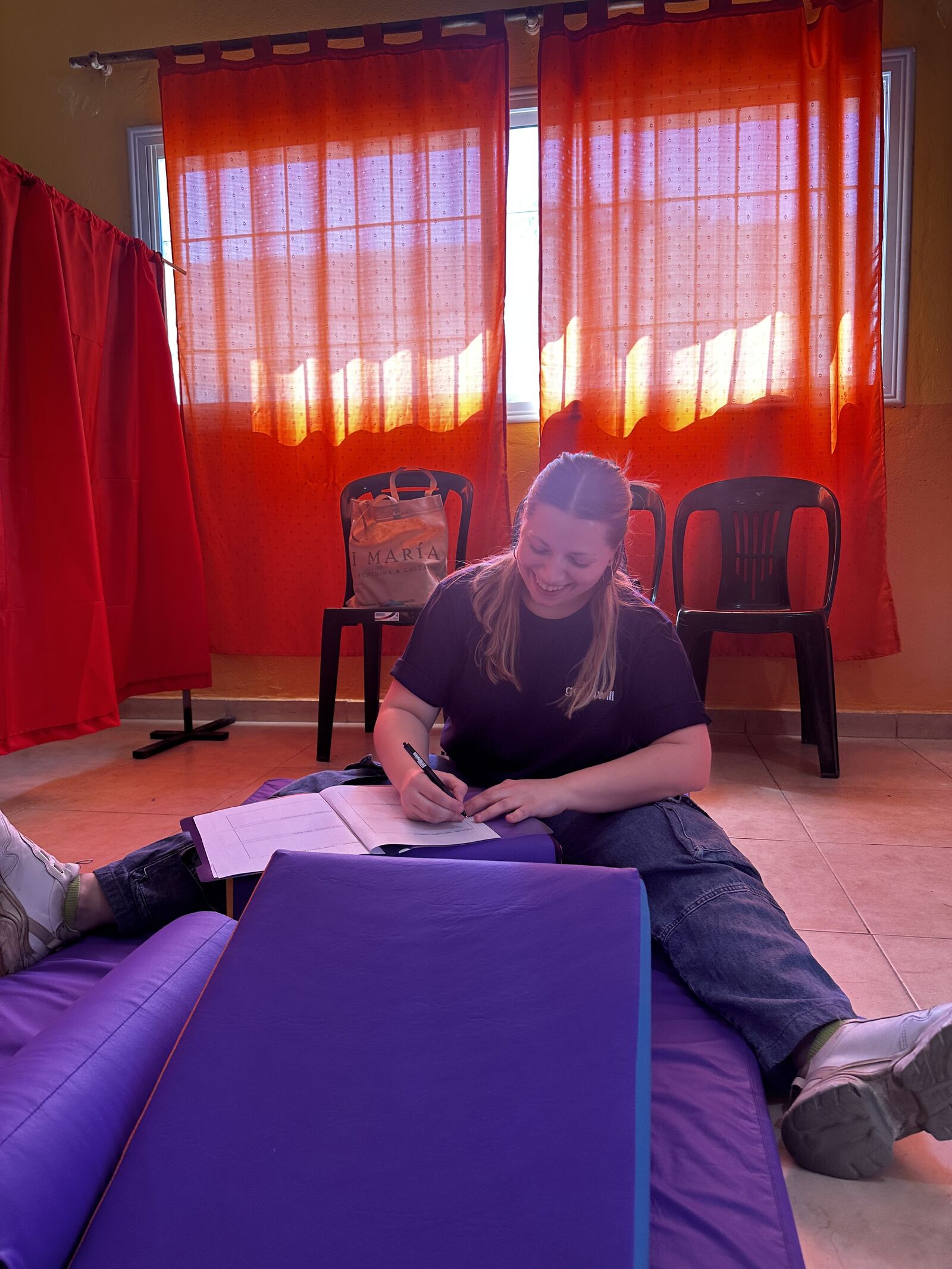 Una profesional anotando en un cuaderno, sentada sobre las colchoneras violetas.