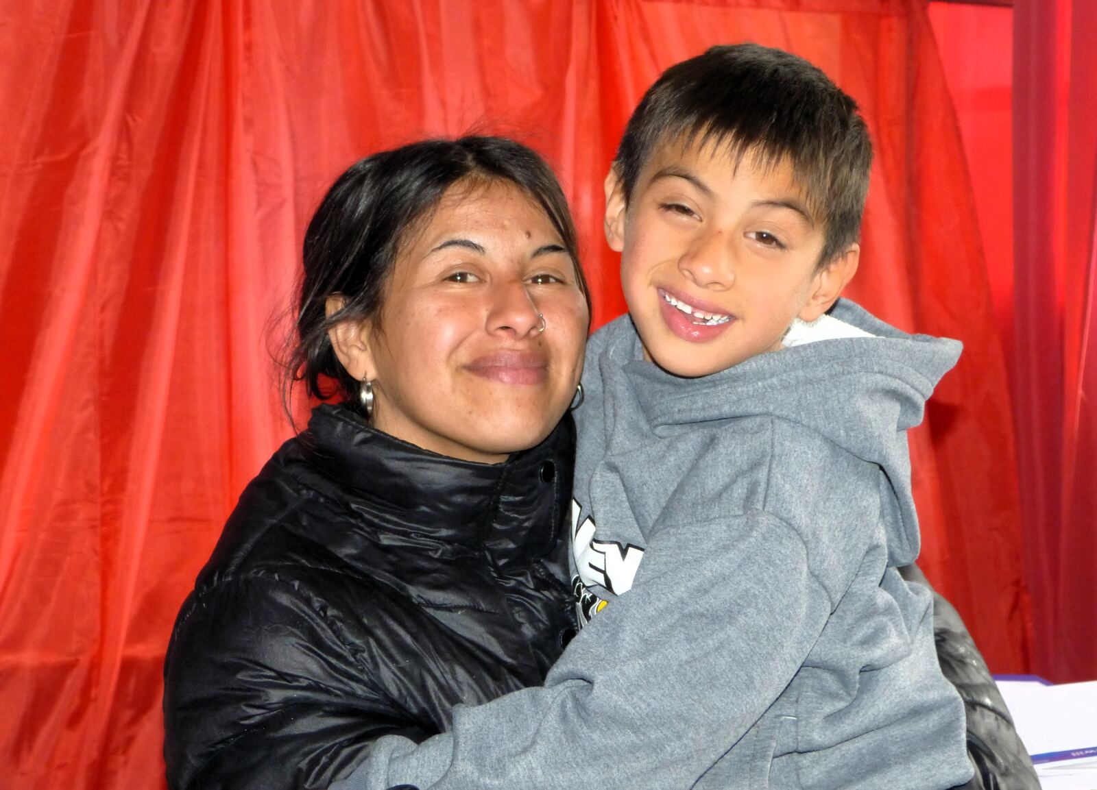 Una mamá y su hijo miran a cámara durante un operativo de la fundación